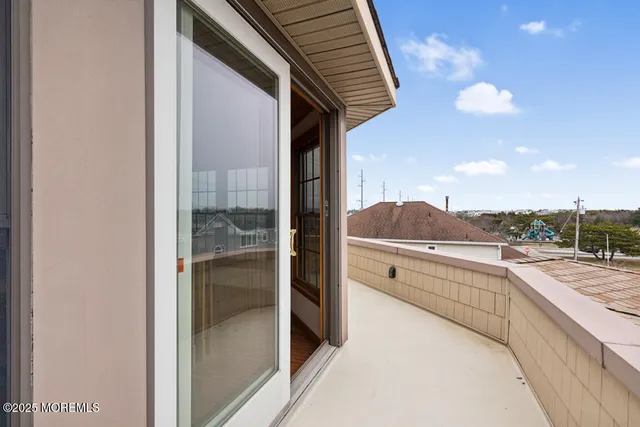a view of a patio with couches chairs and wooden floor