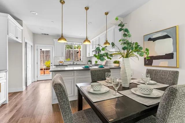 a dining room filled chandelier and wooden floor