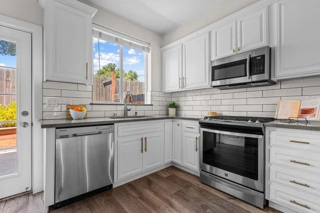 a kitchen with stainless steel appliances granite countertop a stove microwave and sink