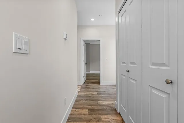a view of a hallway with wooden floor and entryway