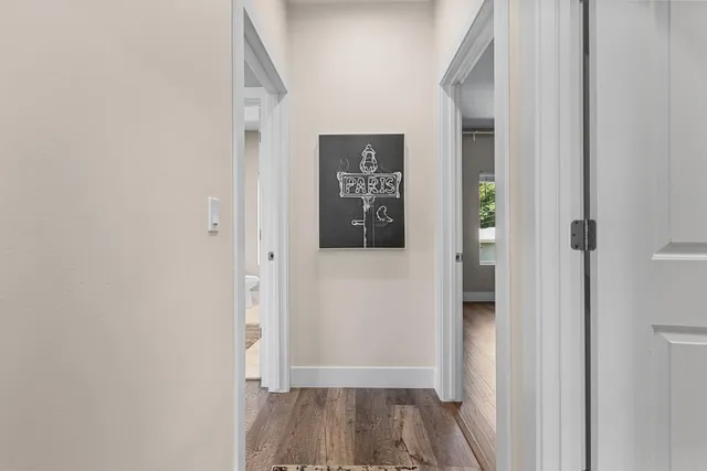 a view of a hallway with wooden floor and closet