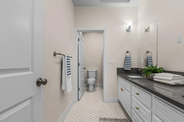 a spacious bathroom with a granite countertop sink and a mirror