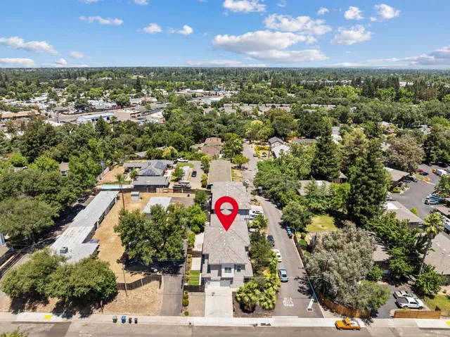 an aerial view of residential houses with outdoor space and trees