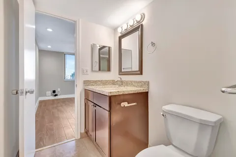 a bathroom with a granite countertop sink toilet and shower