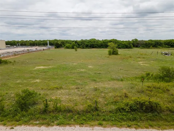 a view of a lake with a big yard and large trees