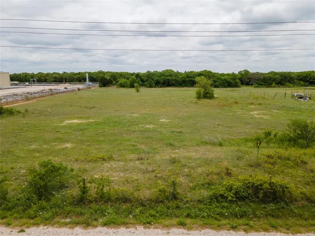 a view of a lake with a big yard and large trees