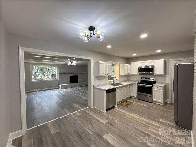 a large kitchen with a refrigerator a stove top oven a sink and dishwasher