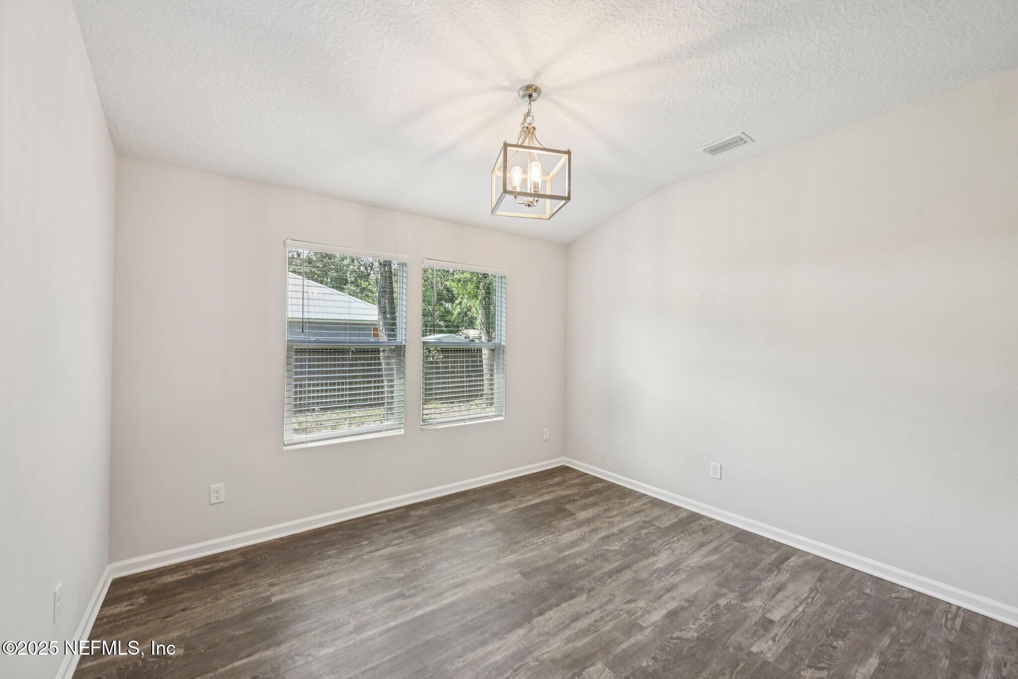 2400 Lundy Road Palatka, FL 32177 - Photo 12 of 34 an empty room with wooden floor ceiling fan and windows