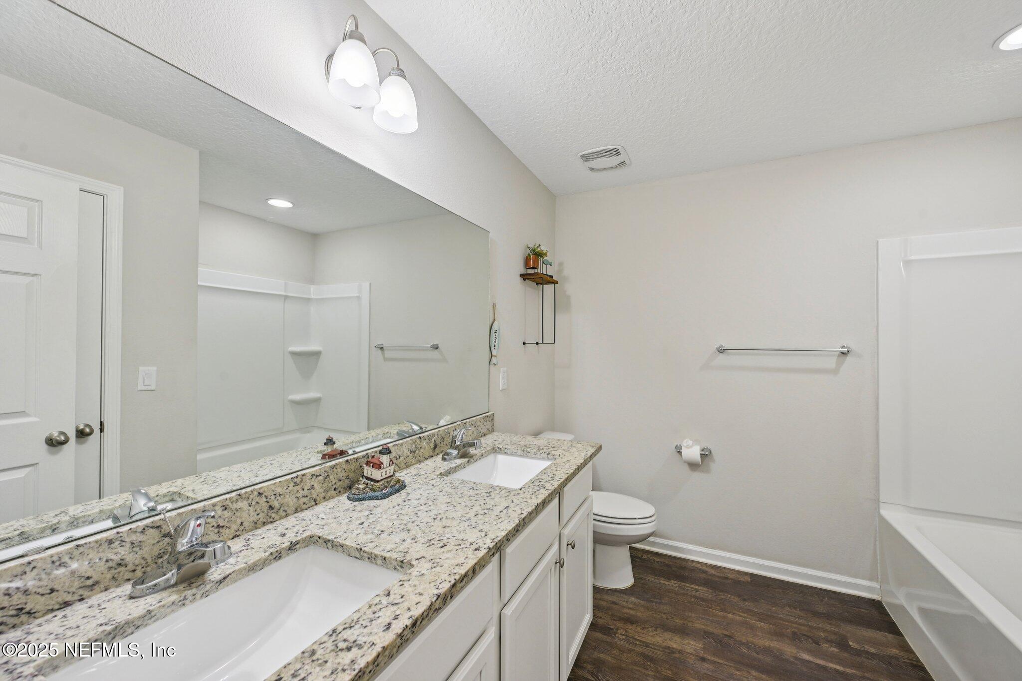 2400 Lundy Road Palatka, FL 32177 - Photo 21 of 34 a bathroom with a granite countertop sink a toilet and shower