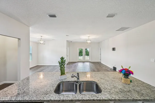 a kitchen with stainless steel appliances granite countertop a sink a stove and a wooden cabinets