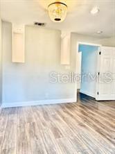 512 Wideview Avenue Tarpon Springs, FL 34689 - Photo 12 of 30 a view of an empty room with wooden floor and a window