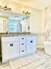 512 Wideview Avenue Tarpon Springs, FL 34689 - Photo 19 of 30 a bathroom with a sink a mirror and a shower