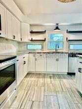 512 Wideview Avenue Tarpon Springs, FL 34689 - Photo 8 of 30 a white kitchen with stove top oven and cabinets