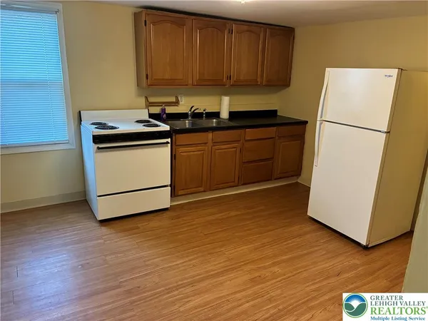 a kitchen with a refrigerator and a stove top oven