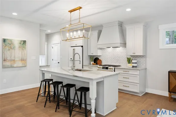 a living room with furniture a table and kitchen view