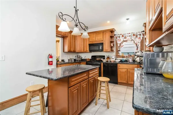 a kitchen with stainless steel appliances granite countertop a sink a stove and a refrigerator