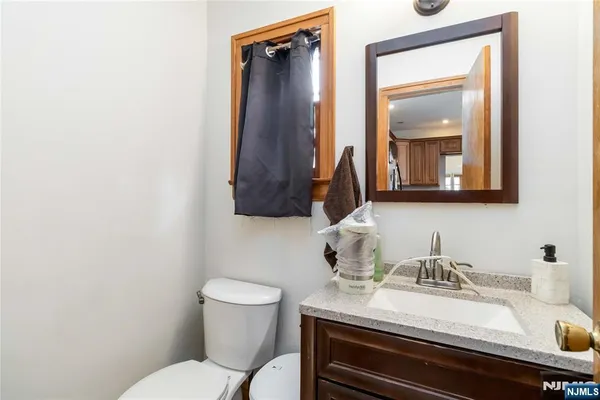 a bathroom with a sink vanity mirror and toilet