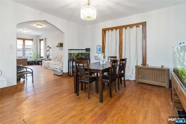 a view of a a dining room with furniture window and wooden floor