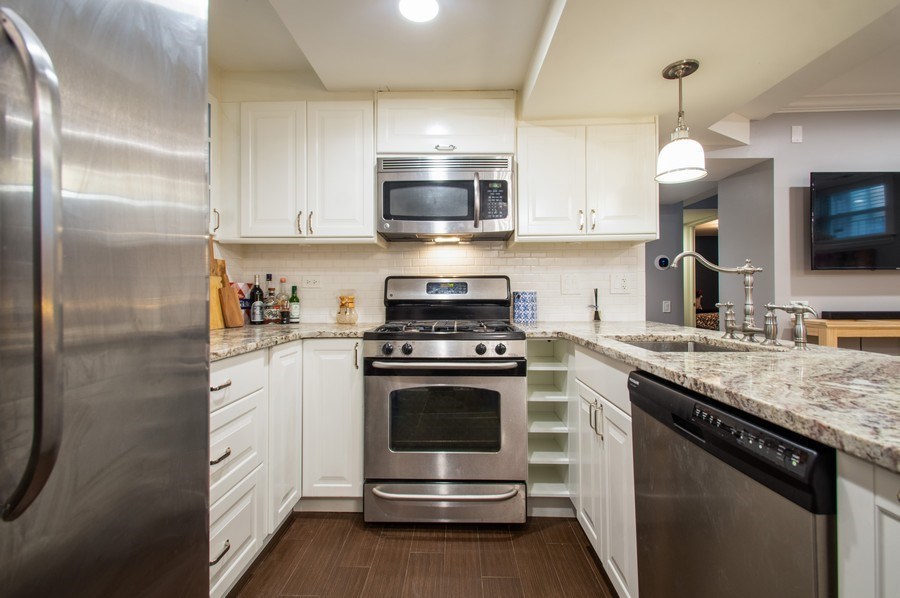 2549 North Clark Street, Unit G Chicago, IL 60614 - Photo 3 of 8 a kitchen with stainless steel appliances granite countertop a stove a sink and a microwave