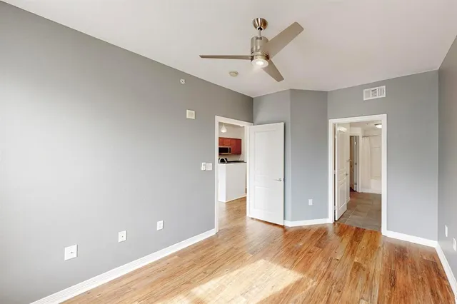 a view of empty room with wooden floor