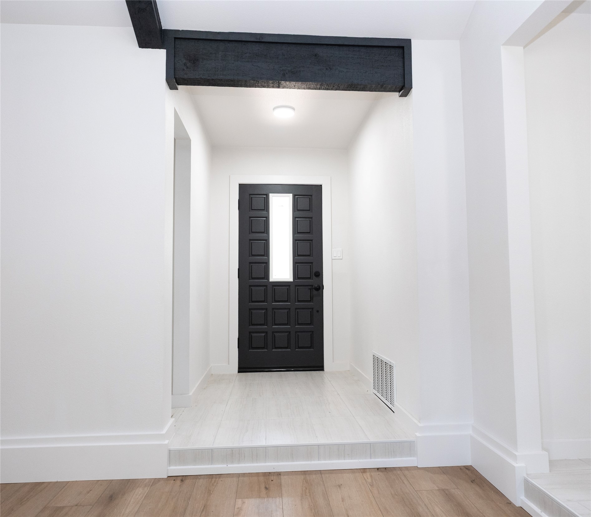 205 Bello Circle Georgetown, TX 78628 - Photo 26 of 36 A welcoming entry features a striking paneled door with a modern window insert and a sleek overhead beam.