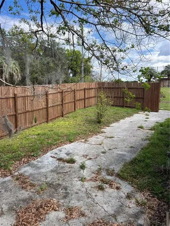 a view of a backyard with wooden fence