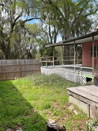 a backyard of a house with lots of green space and fountain