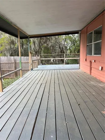 a view of balcony with wooden floor and fence