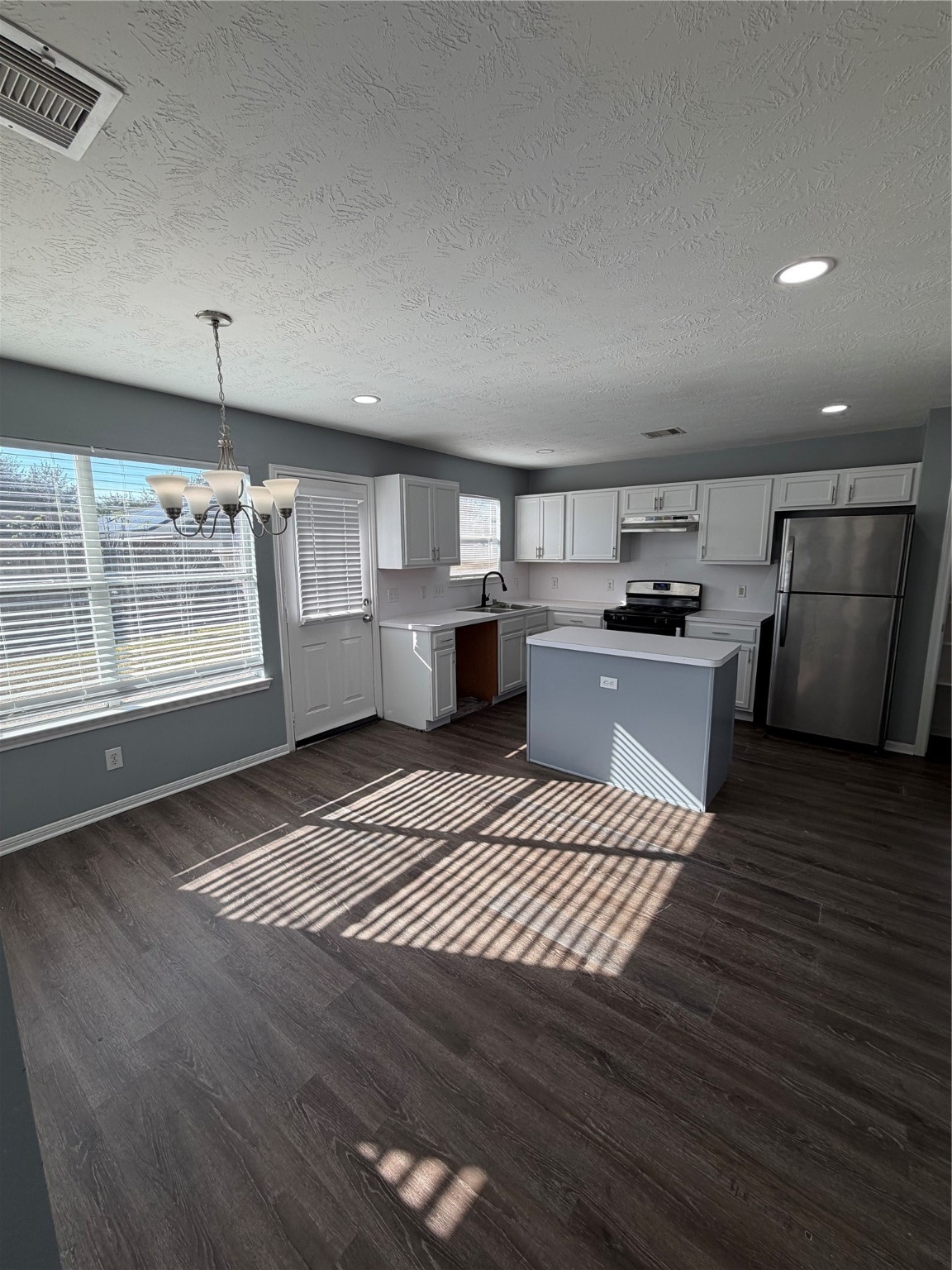 4623 Mi Castillo Court Houston, TX 77045 - Photo 7 of 25 a large kitchen with stainless steel appliances a large counter top stove a sink dishwasher and wooden floor
