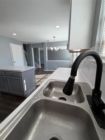 a kitchen with a sink a counter space and cabinets