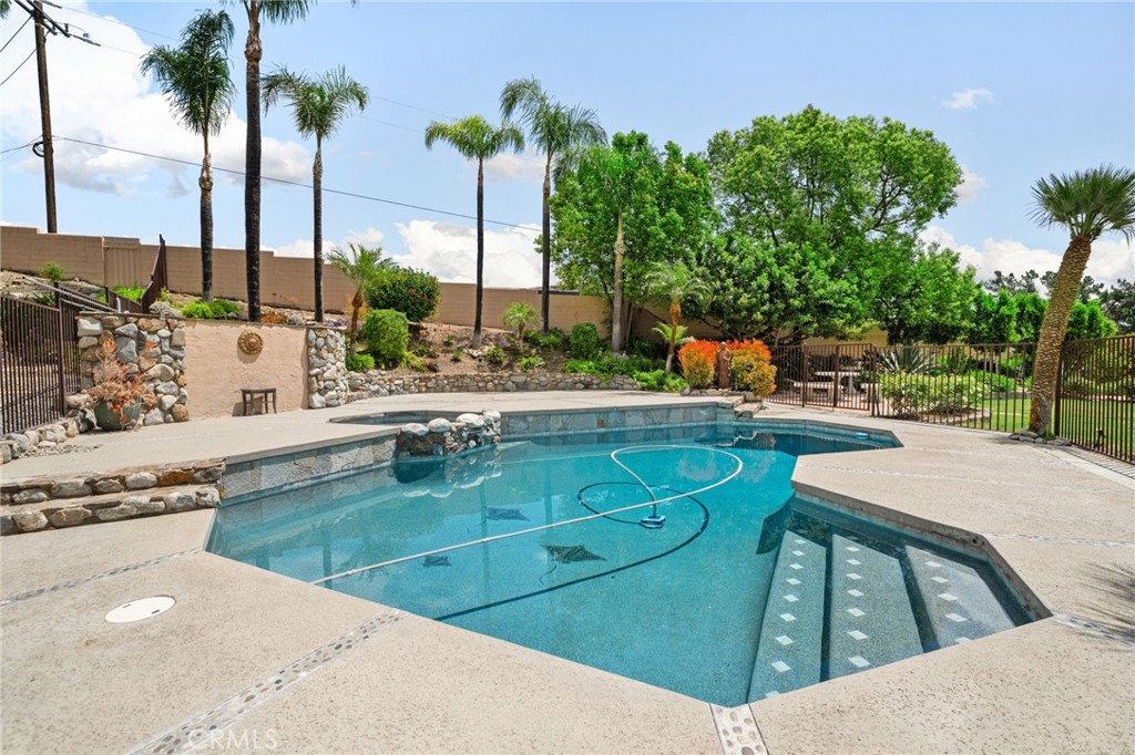 5297 Amethyst Street Rancho Cucamonga, CA 91737 - Photo 2 of 64 a view of a swimming pool with a lawn chairs and palm trees
