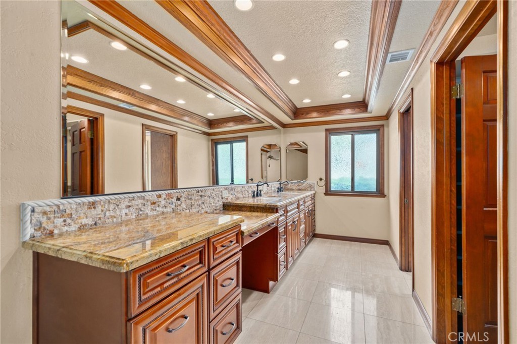 5297 Amethyst Street Rancho Cucamonga, CA 91737 - Photo 26 of 64 a bathroom with a granite countertop sink and a large mirror