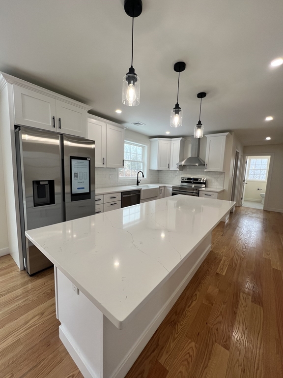 252 East County Road Rutland, MA 01543 - Photo 14 of 42 a large white kitchen with wooden floor and stainless steel appliances