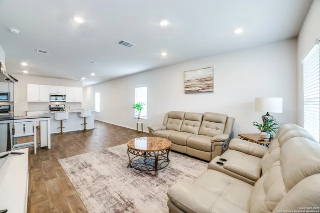 a living room with furniture and wooden floor