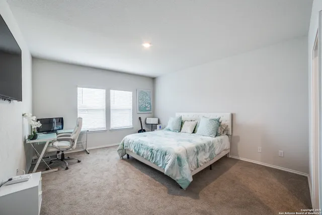 a living room with a bed furniture and a flat screen tv