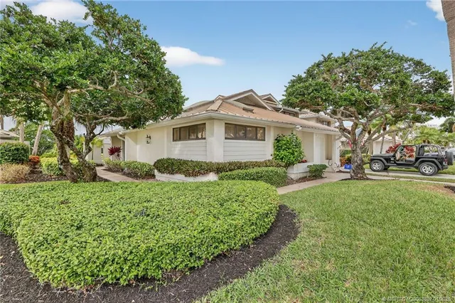a view of a house with a yard and potted plants