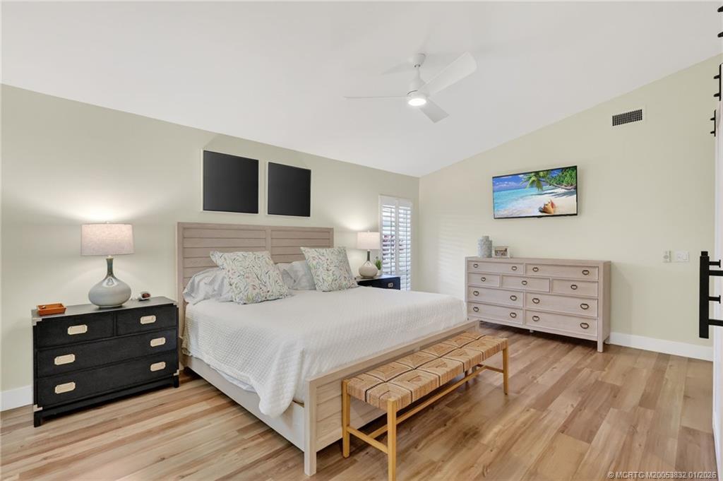 5627 Southeast Foxcross Place Stuart, FL 34997 - Photo 24 of 72 a bedroom with a bed and a night stand