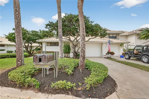 a view of a pathway with a white house next to a yard