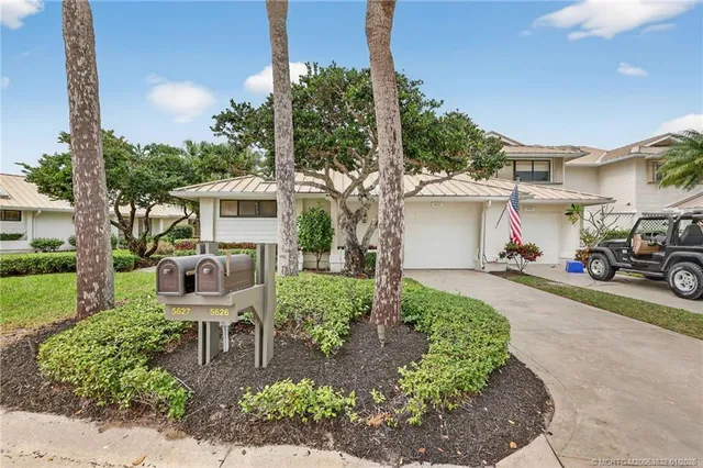 a view of a pathway with a white house next to a yard