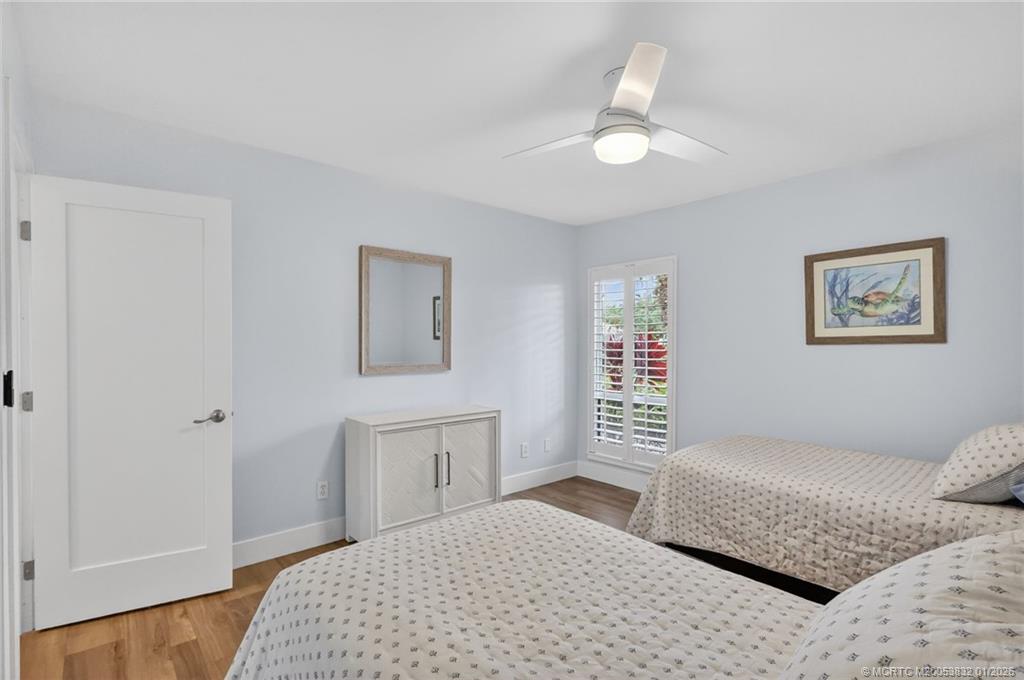 5627 Southeast Foxcross Place Stuart, FL 34997 - Photo 37 of 72 a bedroom with a large bed and a chandelier