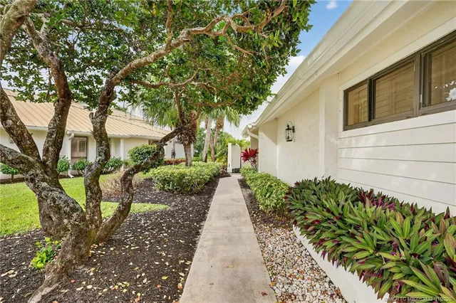 a view of a hallway with wooden floor and a bathroom