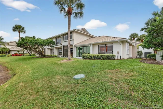 an aerial view of a house with a yard and lake view