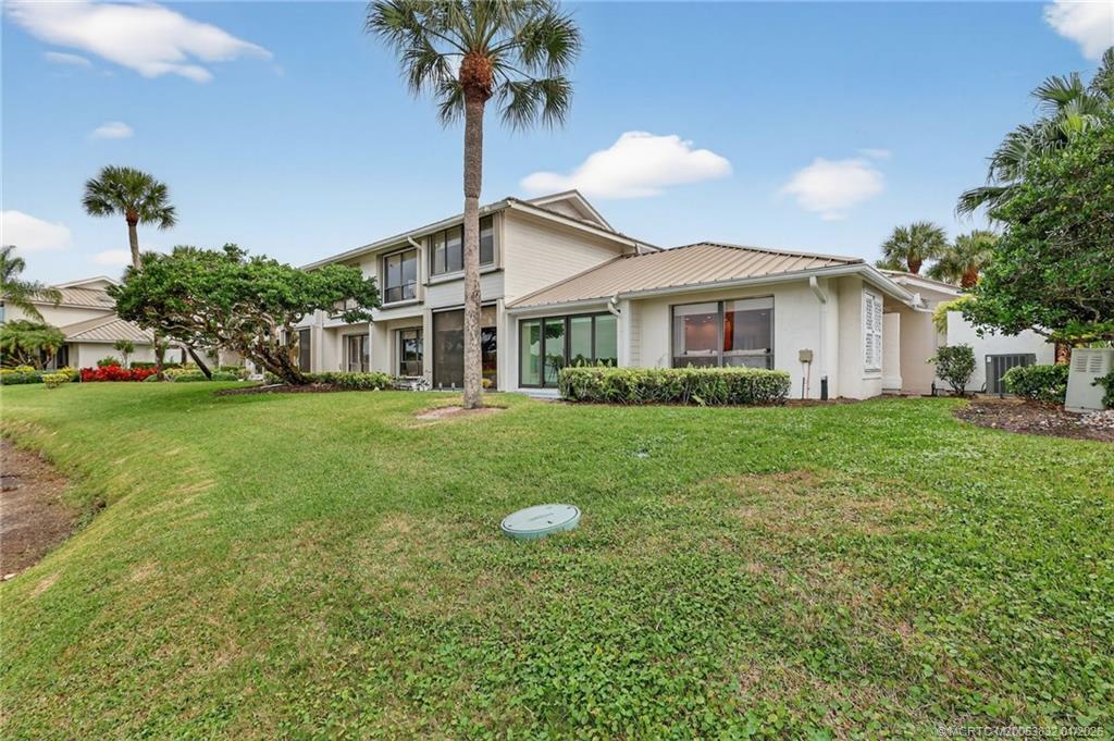 5627 Southeast Foxcross Place Stuart, FL 34997 - Photo 42 of 72 a front view of a house with a garden and trees