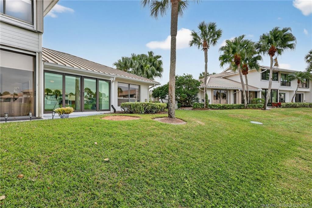 5627 Southeast Foxcross Place Stuart, FL 34997 - Photo 44 of 72 a front view of a house with a yard and potted plants