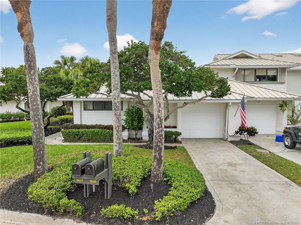 5627 Southeast Foxcross Place Stuart, FL 34997 - Photo 46 of 72 a front view of a house with a yard and garage