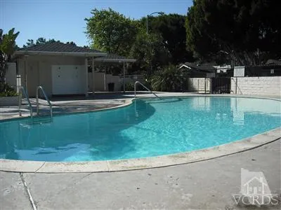 a view of pool with lawn chairs and plants