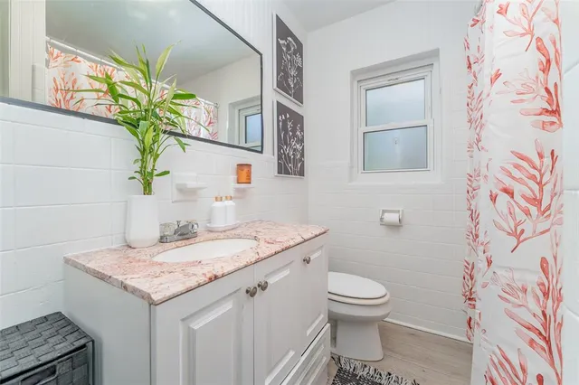 a bathroom with a granite countertop sink a toilet and with mirror