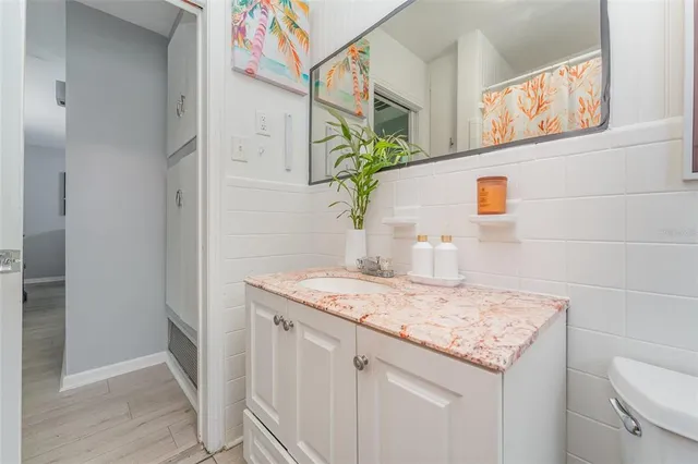 a bathroom with a granite countertop sink and a toilet