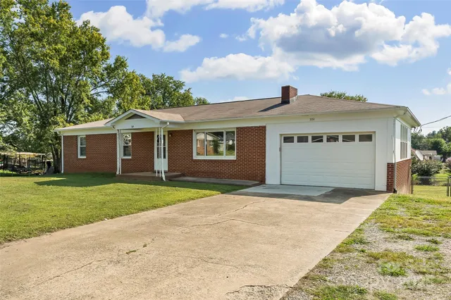 a front view of a house with a garden and yard