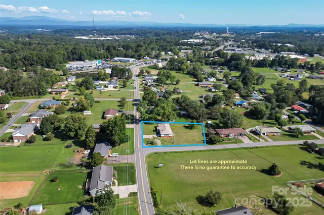 an aerial view of residential houses with outdoor space and trees